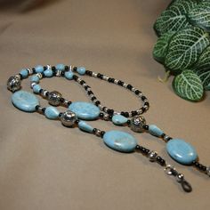 "This eyeglass chain has 4 large turquoise gemstone beads (a bit over 1\" long), smaller teardrop shaped turquoise gemstone beads, decorative silver metal beads in 2 sizes, and black & silver glass seed beads. You will never misplace your glasses again!! Length - 30\" Weight - 2.26 oz (63 Grams) Multi-strand flexible stringing wire Silicone ends" Adjustable Turquoise Necklace With Polished Beads, Adjustable Silver Turquoise Necklace With Polished Beads, Adjustable Beaded Turquoise Necklace, Adjustable Turquoise Beaded Chain Necklace, Turquoise Jewelry With Black Beads For Festival, Turquoise Teardrop Beaded Chain Jewelry, Turquoise Teardrop Jewelry With Beaded Chain, Turquoise Teardrop Beaded Jewelry, Adjustable Turquoise Jewelry With Black Beads