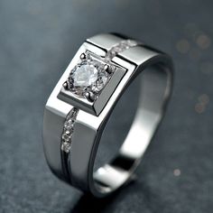 a white gold ring with diamonds on the sides and a diamond set in the middle