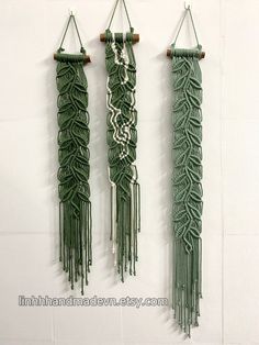 three green macrame wall hangings on a white wall