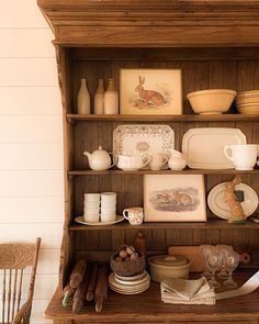 a wooden hutch filled with dishes and plates