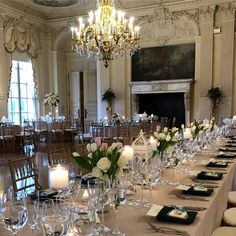 a long table is set up with wine glasses and place settings for formal dinner guests