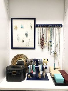 jewelry is displayed on display in a white room with blue and black accessories hanging from the wall