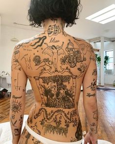 the back of a woman's body with many tattoos on her upper and lower half