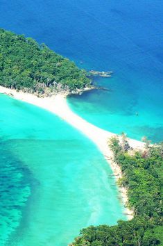 an aerial view of a tropical island with white sand and clear blue water, surrounded by lush green trees