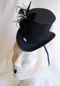 This simple and elegant gothic mini top hat is covered with beautiful black silk shantung. It is embellished with black veil, a luxurious spray of curled ostrich plums and a sparkling flower shaped rhinestone button. Also available in white and ivory here : https://www.etsy.com/shop/BizarreNoir?ref=seller-platform-mcnav&section_id=14329940 If you're interested in another color, please, send me a message to talk about your options. This mini top hat is fully lined with satin and attaches to t High Crown Fitted Hat For Costume, Fitted High Crown Hat For Costumes, Fitted Top Hat With Curved Brim For Costume, Gothic High Crown Costume Hat, Gothic Top Hat With Short Brim For Halloween, Gothic Fitted High Crown Costume Accessories, Witchy Fitted Party Hat, Fitted Witchy Party Hat, Gothic Short-brim Hat For Costume Party