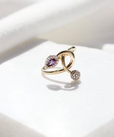 A beautiful and romantic 14K gold ring featuring a teardrop purple cubic zirconia stone and a little globe. This ring has a unique design and is one of a kind. We wont be making a second one of this ring, so if you love it hurry up! #february #birthstone #purple #ring #gold #aesthetic #minimalist #bridal #jewelry #unique Modern Twist Jewelry With Gemstone For Gift, Luxury Rose Gold Infinity Jewelry, Modern Twist Rose Gold Promise Jewelry, Elegant Infinity Gemstone Jewelry, Rose Gold Infinity Jewelry For Promise, Rose Gold Infinity Promise Jewelry, Infinity Gemstone Jewelry For Anniversary, Infinity Halo Jewelry Gift, Fine Jewelry With Infinity Gemstone