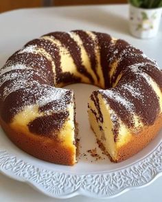 a cake that has been cut into pieces on a white plate with a flower pot in the background