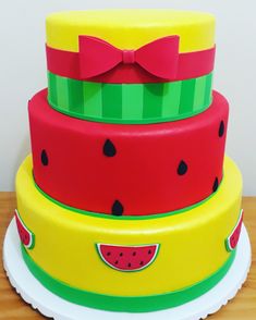 three tiered cake decorated with watermelon slices and a red bow on top