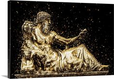 a golden statue sitting on top of a wooden table next to a black background with gold sprinkles