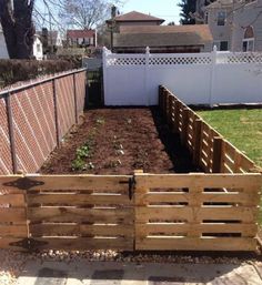 a wooden garden bed in the middle of a yard