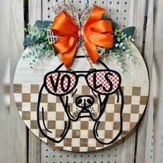 a wooden sign with a dog wearing sunglasses and a bow on it's head