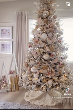 a white christmas tree with gold and silver ornaments