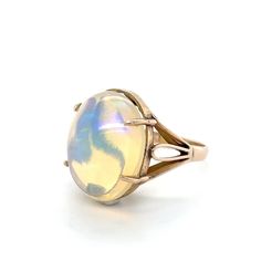 "Flashes of color play from this stunning 9.54 carat opal cabochon set in a lovely 14K yellow gold ring with swirling metal details.  Marked \"14K\".  A wonderful addition to your personal jewelry collection. FREE SHIPPING! Details:  14K Yellow Gold: (shown in picture) Natural Opal: (1) 17.6 mm x 14.2 mm oval cabochon Approximate Gem Weight: 9.54 Carat Gem Color: Yellow with multi-color flashes Ring Size: 6 3/4 Total Weight: 4.9 grams FREE Domestic Shipping by USPS Priority Mail Delivery Confirmation and includes insurance. If the item is to be shipped internationally Etsy will calculate postage. Please notify us at time of purchase if you are buying more than one item and we will gladly combine shipping. 7 day \"no hassle\" return policy money back guarantee. If for any reason you are not Formal Yellow Gold Ethiopian Opal Ring, Formal Ethiopian Opal Cabochon Ring, Yellow Gold Opal Ring With Cabochon, Yellow Gold Ethiopian Opal Ring In Oval Cabochon Shape, Formal Opal Oval Cabochon Ring, Yellow Gold Ethiopian Opal Oval Cabochon Ring, Formal Opal Ring With Oval Cabochon, Ethiopian Opal Oval Cabochon Ring In Yellow Gold, Elegant Iridescent Cabochon Ring