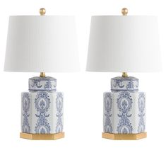 pair of blue and white ceramic lamps with gold accents on each lamp, one is turned off