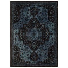 a blue and black rug with an intricate design on the center, in front of a white background