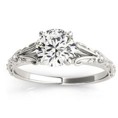 a white gold engagement ring with an intricate filigreet design on the side