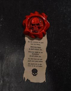 a red wax stamp with a skull on it and a poem written in the center