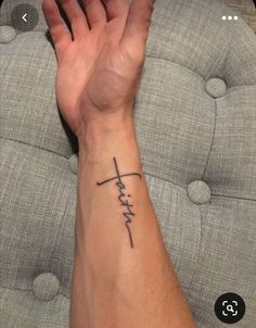 a person's arm with a cross tattoo on it