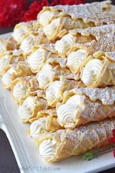 a white plate topped with pastry covered in powdered sugar