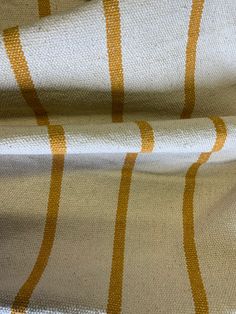 an orange and white striped fabric with some yellow lines on the top of it,