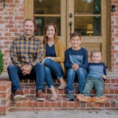 a family sitting on the front steps of their home