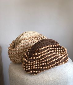 two beaded hats sitting on top of a white mannequin headdress