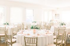 the tables are set up with white linens and gold chairs for an elegant wedding reception