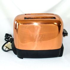 a close up of a toaster on a white surface with a black cord attached to it