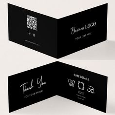 two black business cards with white writing on the front and back, one is folded in half