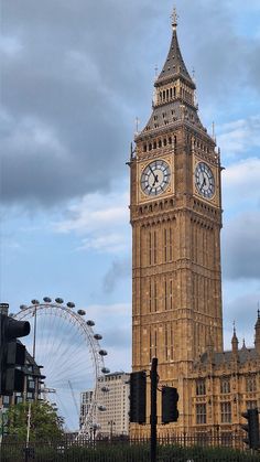 the big ben clock tower towering over the city of london, england with ferris wheel in the background