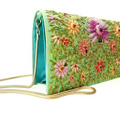 "Stunning one-of-a-kind statement clutch, a lush garden of glowing silk flowers hand embroidered on a rich turquoise/green silk background, and embellished with metallic threads and genuine star ruby stones. The sumptuous luster of silk and the exquisite embroidery make this a show stopping purse! The lotus flower is a symbol of rebirth and new beginnings - perfect for weddings and life's transitions. The word Zardozi means \"gold thread\". It is an elaborate and intricate embroidery using metal Elegant Green Bag With Floral Embroidery, Elegant Green Bags With Floral Embroidery, Green Embroidered Evening Bag, Elegant Embroidered Green Bags, Green Embroidered Evening Bag For Party, Elegant Green Embroidered Bag, Elegant Green Embroidered Bags, Elegant Embroidered Green Evening Bag, Elegant Green Embroidered Evening Bag