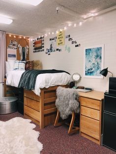 a dorm room with a bed, desk and dresser