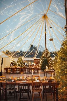 an outdoor dining area with christmas trees and lights