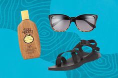 two pairs of sandals, sunglasses and a bottle of sunscreen on a blue background