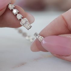 a woman's hand holding a diamond ring with three diamonds on the top of it