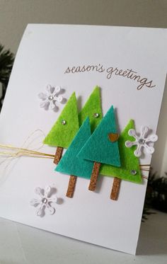 a christmas card with three felt trees on it