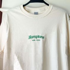 "\"Hamptons New York\" embroidered on a cute boxy graphic tee. This t-shirt makes for a great staple piece in any wardrobe! It has a classic fit with thick cotton fabric. *Sizes are unisex, I'd suggest sizing up if you want a more relaxed fit. * 100% cotton * Gildan Ultra Cotton * Fabric weight: 6.0 oz/y² (203.4 g/m²) * Pre-shrunk * Boxy fit * Shoulder-to-shoulder taping * Seamless double-needle 7⁄8″ (2.2 cm) collar * Double-needle stitched sleeves and bottom hem * Quarter-turned to avoid crease Cheap Graphic Tee With Embroidered Logo, Cheap Embroidered Logo Graphic Tee, Luxury Classic T-shirt With Branding, Cheap Relaxed Fit Shirt With Embroidered Text, Cheap Embroidered Graphic Tops For College, Hamptons Graphic Design, Hamptons Bachelorette Party, Hamptons Bachelorette, Hamptons New York