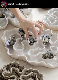 a person reaching for some oysters on a platter