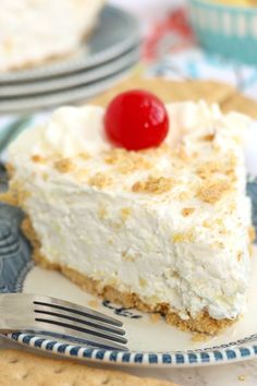 a piece of cheesecake on a plate with a fork and bowl in the background