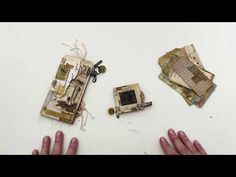 two hands are shown next to an old camera and some pieces of paper that have been torn off