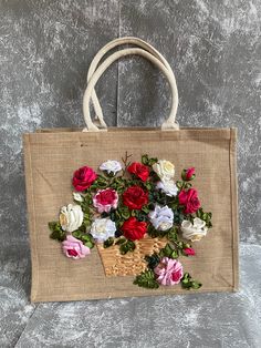 a bag with flowers painted on it is sitting on a table next to a wall