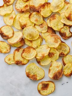 sliced potatoes on a white surface with seasoning