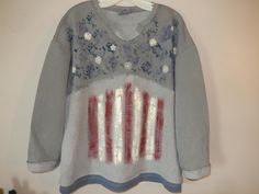 This unique light weight v neck patriotic sweatshirt is a must be added to the wardrobe top!   The top is the gray sweatshirt with splotches of navy-blue paint with little stars and dainty daisy's.  The second section is inside out and painted with dark red and cream stripes to represent our flag.  The bottom has a navy blue trim that looks like it's a layered t shirt under the sweatshirt.  This classy Americana tee could be worn with your favorite pair of jeans or a pair of leggings.  This lightweight sweatshirt is so soft and overflowing with comfort that you will think you are in your pjs!  The most premium sweatshirt you can get your hands on. You will want to live in this.  Great gift idea too! Please note, while I do my best to capture highest quality pictures, the color may very sli American Flag Print Relaxed Top For Fall, American Flag Print Relaxed Fit Top For Fall, Relaxed Fit American Flag Print Top For Fall, Spring Flag Print Long Sleeve Tops, Oversized Crew Neck Tops For 4th Of July, Long Sleeve Tops With Flag Print For Spring, Spring Long Sleeve Tops With Flag Print, Oversized Casual Tops For 4th Of July, Casual Oversized Tops For 4th Of July