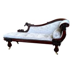 an ornate wooden chaise lounge with white upholstered fabric