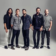 five men standing in front of a gray background