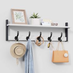 a wall mounted shelf with hooks and hats on it