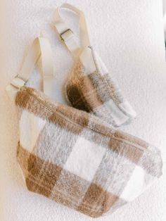 a brown and white checkered purse sitting on top of a towel