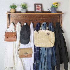 a wooden coat rack filled with purses and hats