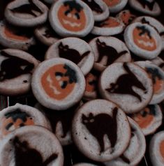 some cookies with icing on them are decorated like bats and pumpkins in the shape of cats