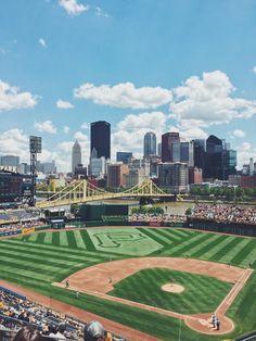 a baseball field with the city in the background